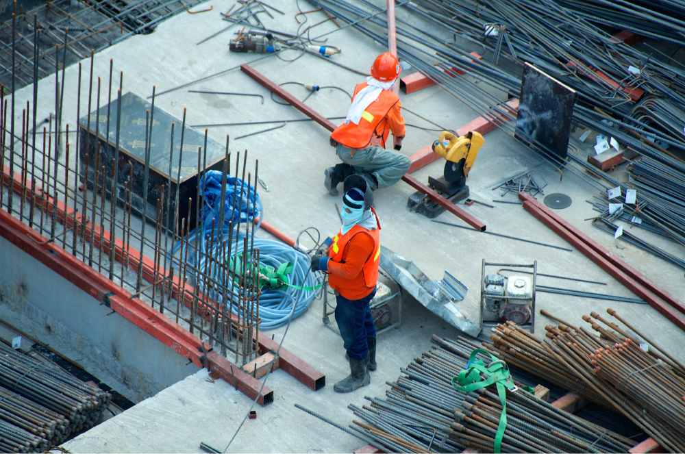 Two workers on a construction site wearing personal protective equipment